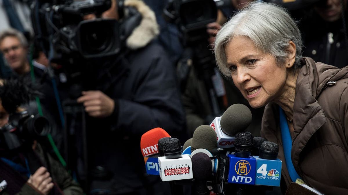 Jill Stein speaking into several microphones