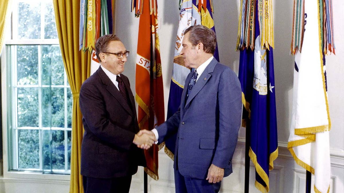 Henry Kissinger standing next to former President Richard Nixon
