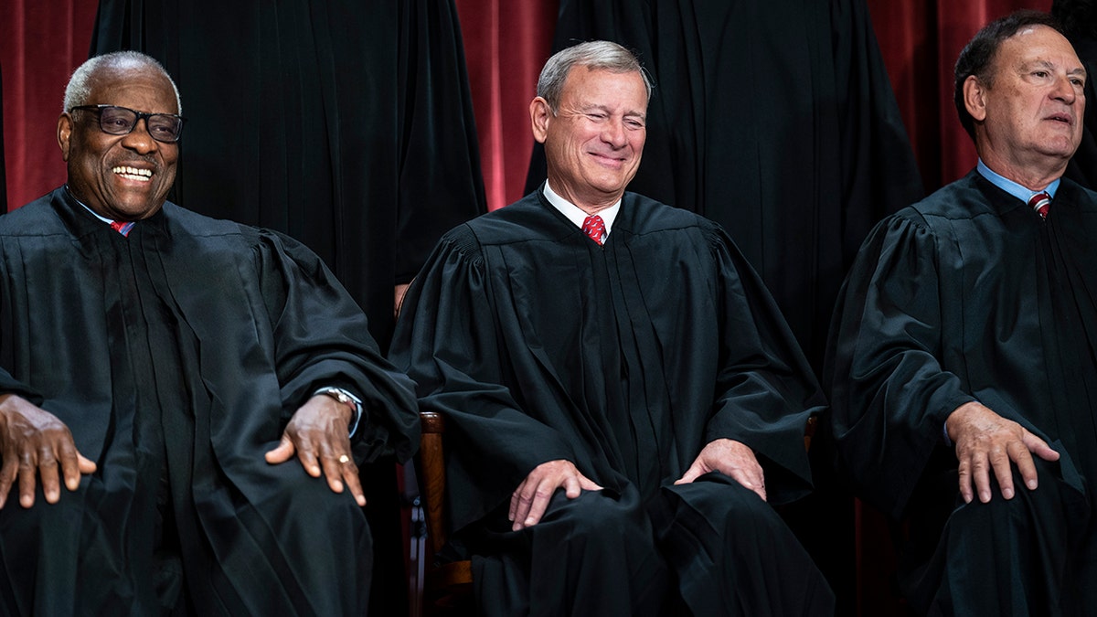 Justices Thomas and Alito, left and right, with Chief Justice Roberts at center