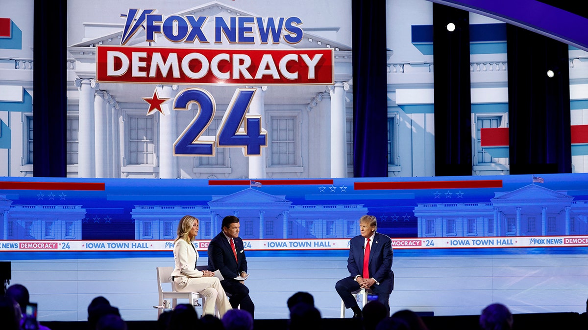 Fox News hosts Martha MacCallum and Bret Baier talking with Trump on stage during Fox News town hall