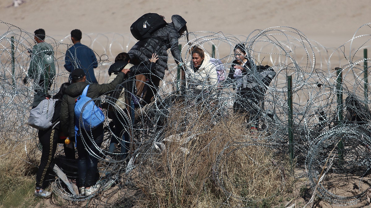 Migrants cross razor wire in Texas