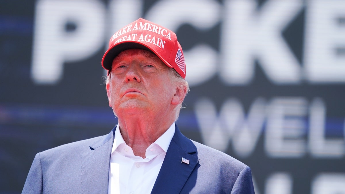 Donald Trump in blue blazer and red MAGA hat