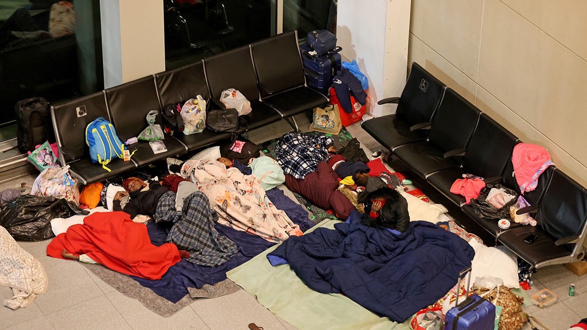 migrants sleeping in airport terminal