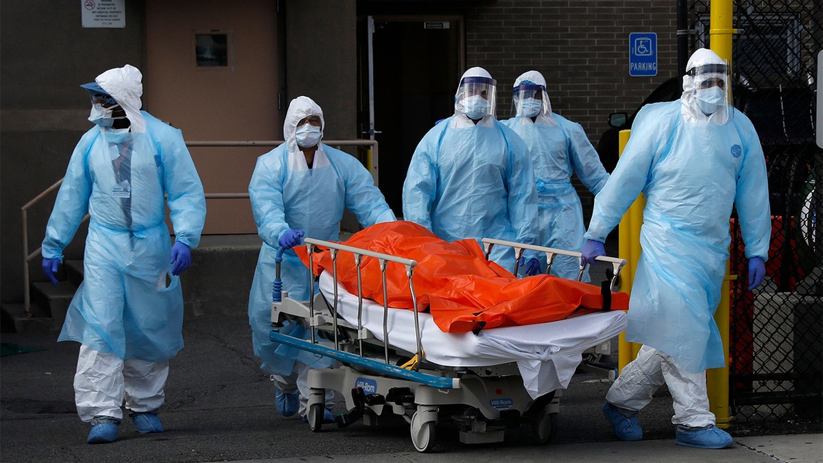 New York City health care workers wheel the body of a deceased person during the COVID-19 pandemic