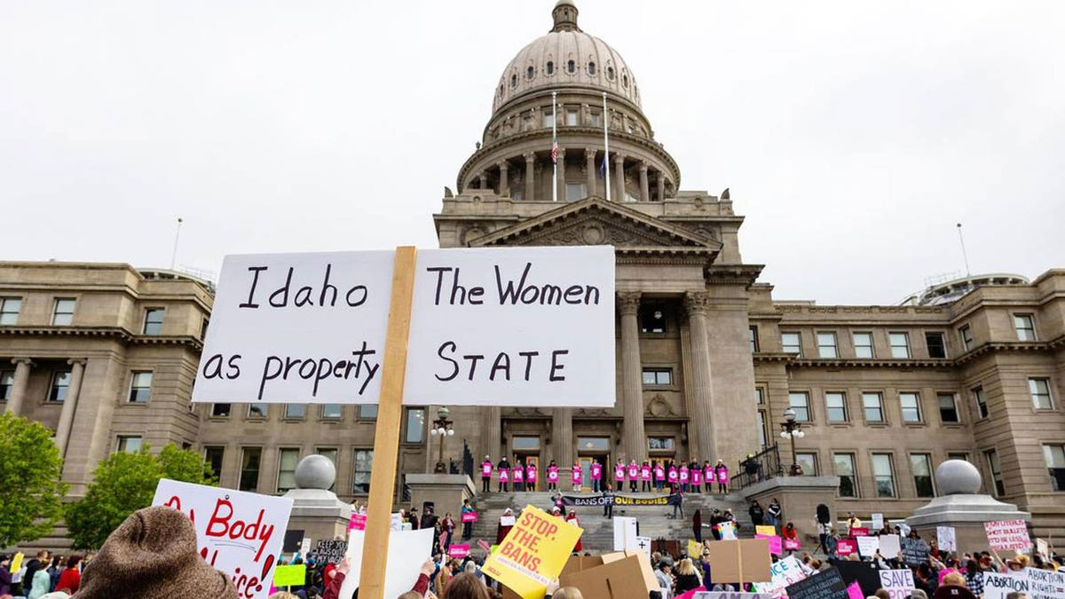 An attendee at an abortion rights rally holds a sign outside the Idaho Capitol