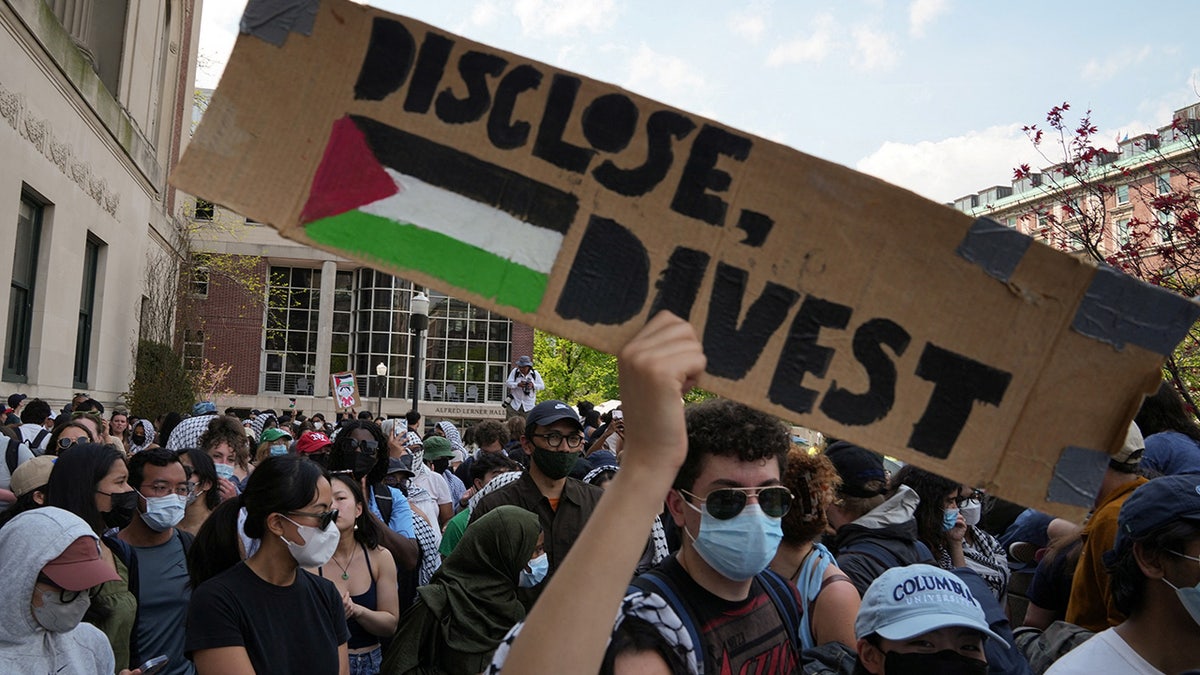 A protester holds a sign during a march on Columbia University campus in support of a protest encampment supporting Palestinians