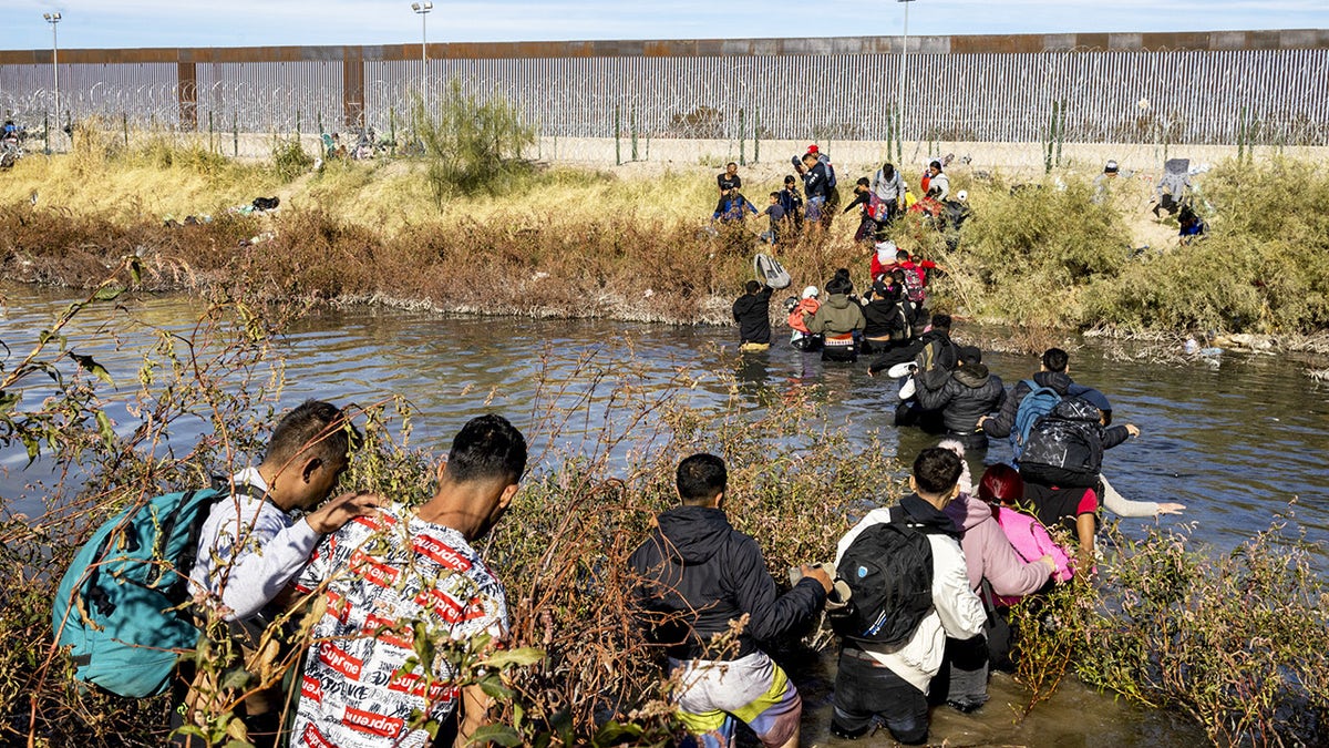 Migrants, predominantly from Venezuela, cross the Rio Grande