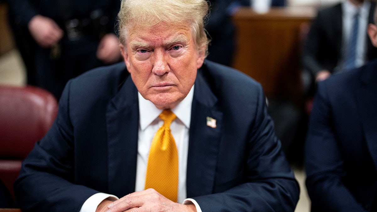 Donald Trump in yellow tie at defense table in court