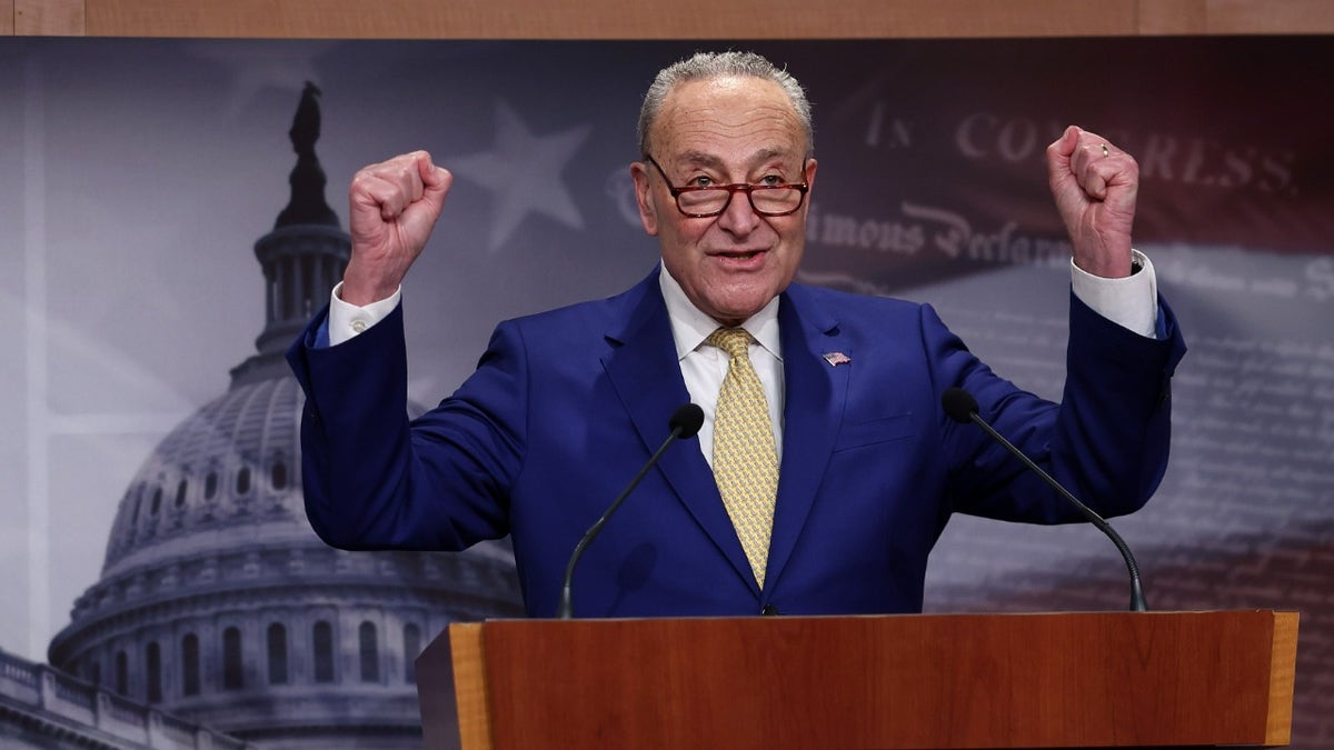 Chuck Schumer raising his hands