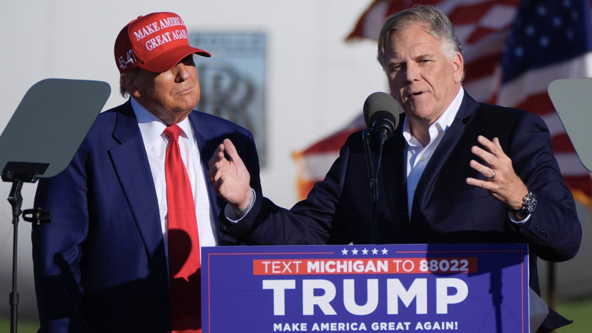 Republican presidential candidate former President Donald Trump listens as Michigan Senate candidate former Rep. Mike Rogers speaks at a campaign rally in Freeland, Mich., Wednesday, May 1, 2024. (AP Photo/Paul Sancya)