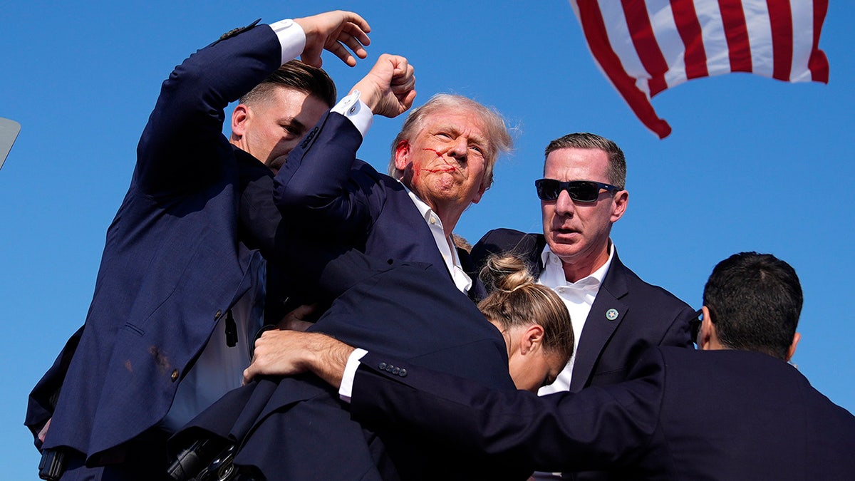 Republican presidential candidate former President Donald Trump is surrounded by U.S. Secret Service agents at a campaign rally