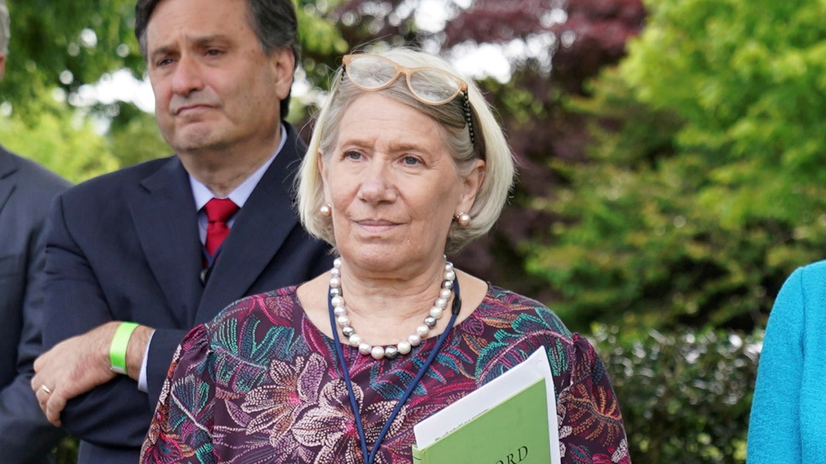 Senior Adviser to the President Anita Dunn and other staff members stand without protective face masks in the Rose Garden of the White House in Washington, U.S., May 13, 2021.