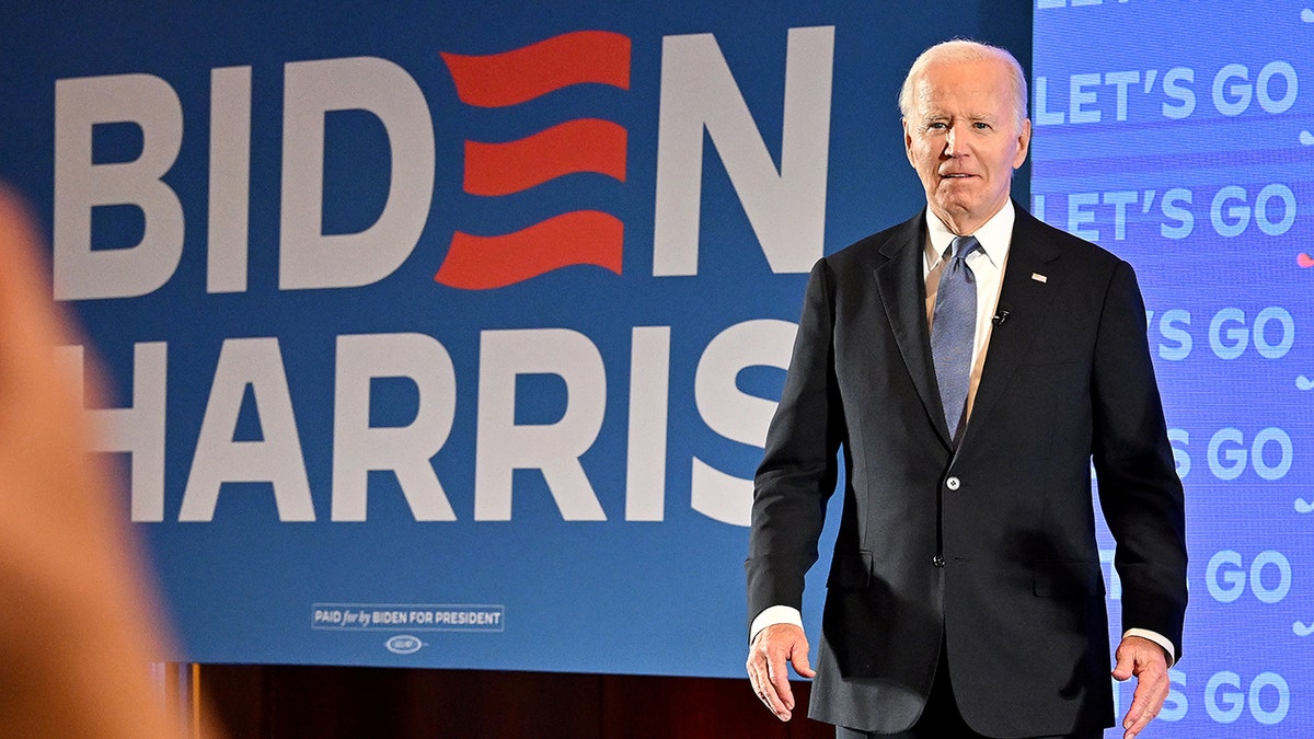 President Biden with large Biden/Harris sign behind him