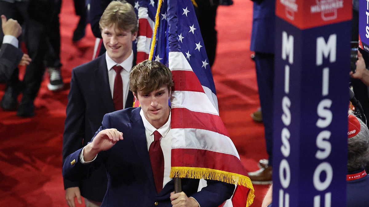 Attendees carry American flags on Day 3 of the Republican National Convention