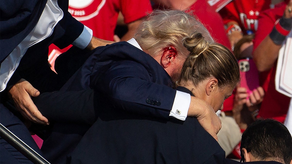 Former President Trump being taken off stage by Secret Service.