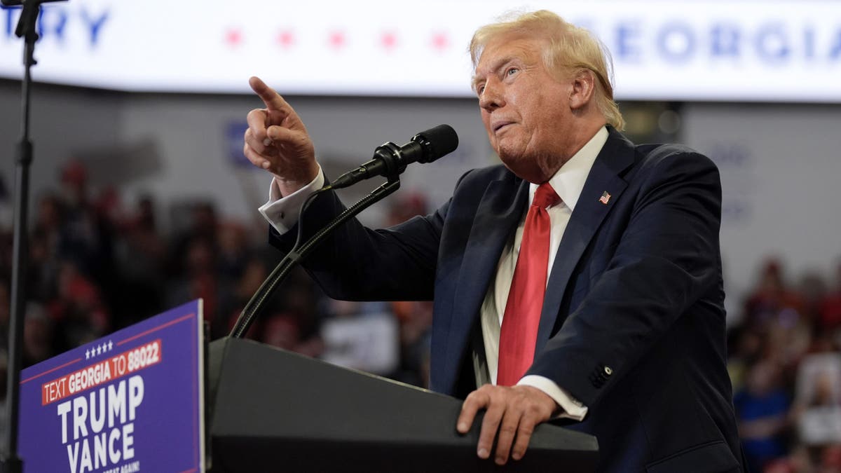 Donald Trump at rally podium pointing