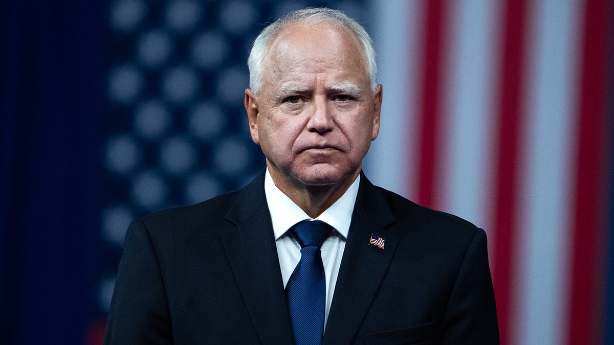 Minnesota Governor Tim Walz standing before an American flag