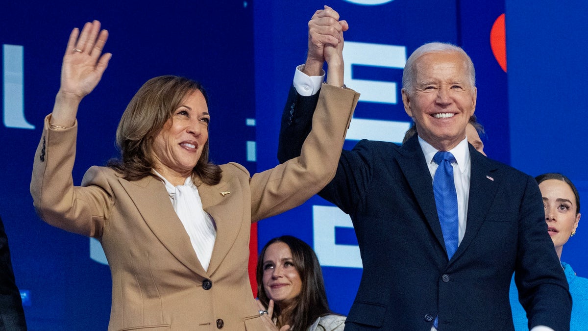 Democratic presidential nominee Vice President Kamala Harris, left, clasps her hand in the air with President Joe Biden at the Democratic National Convention, Monday, Aug. 19, 2024, in Chicago. (AP Photo/Jacquelyn Martin)