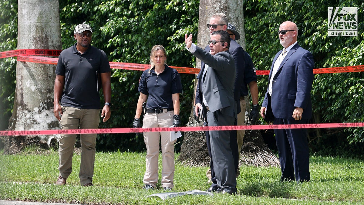 FBI investigators gather evidence from the perimeter of Trump International Golf Club in West Palm Beach