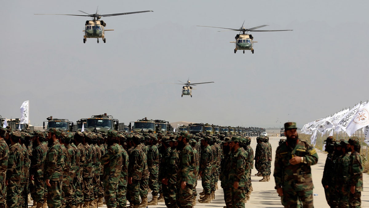 Helicopters fly above soldiers in formation