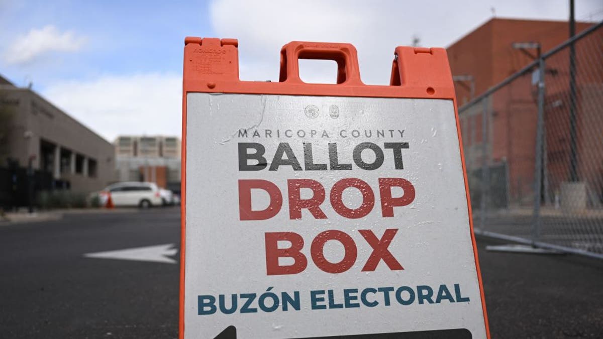 A sign directs Arizona voters to a ballot drop box for early voting outside the Maricopa County Tabulation and Election Center in Phoenix.