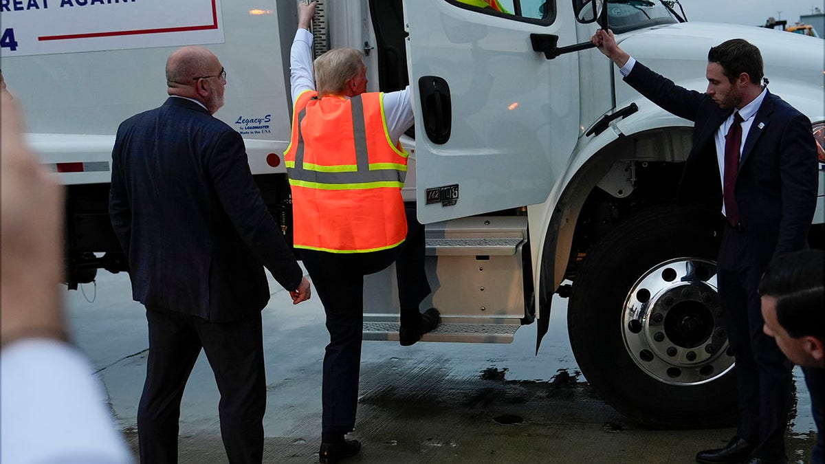 trump getting into a garbage truck