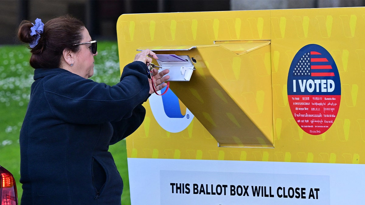 A woman ballot into drop box