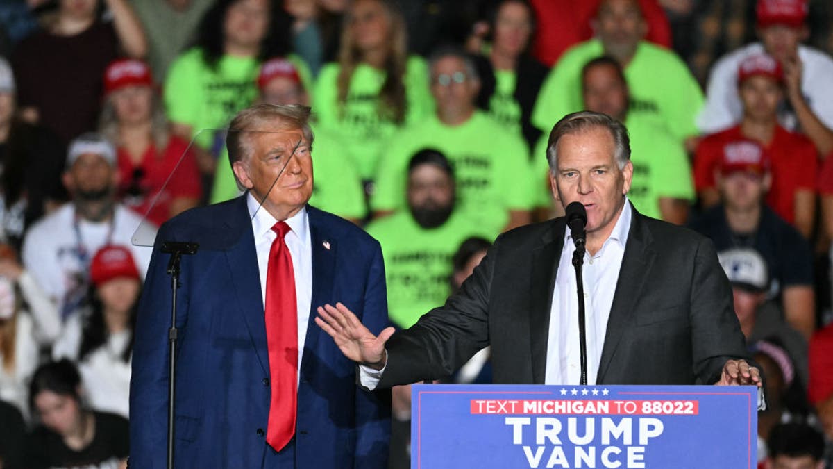 Mike Rogers at podium with Trump to his right