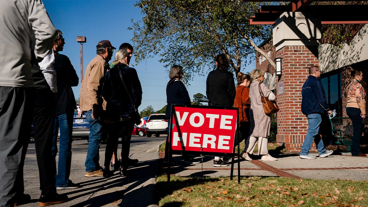 Voters wait in line to cast their ballots during the first day of early voting at a polling station in Wilmington, North Carolina, on Thursday, Oct. 17, 2024.