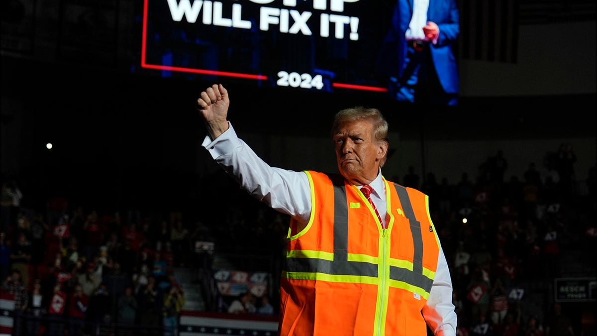 Donald Trump in orange safety vest raising army at rally