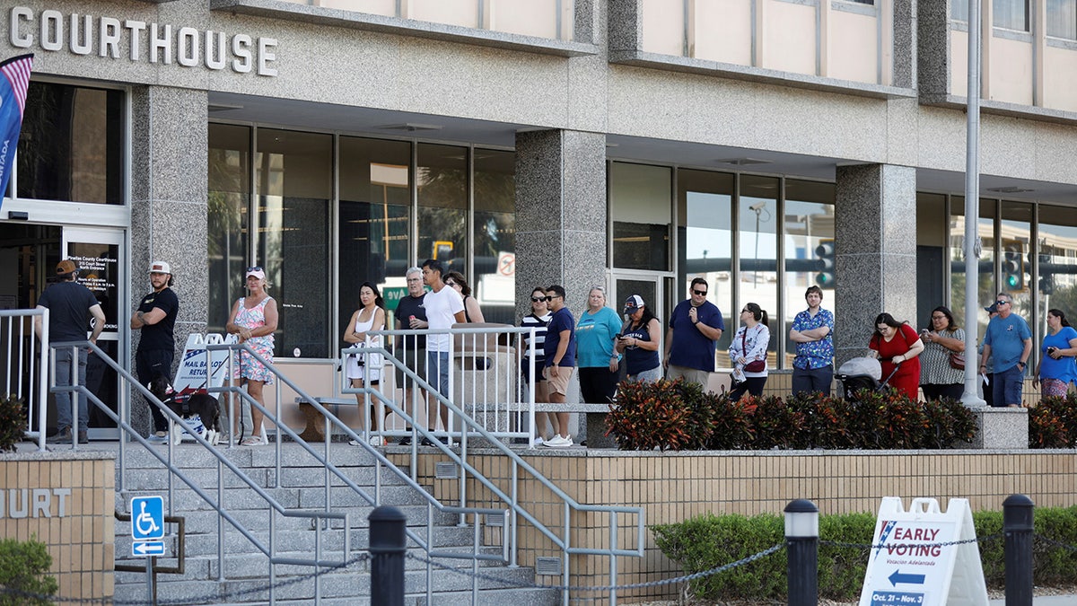 Florida residents wait in line at an early polling precinct to cast their ballots in local, state, and national elections, in Clearwater, Florida