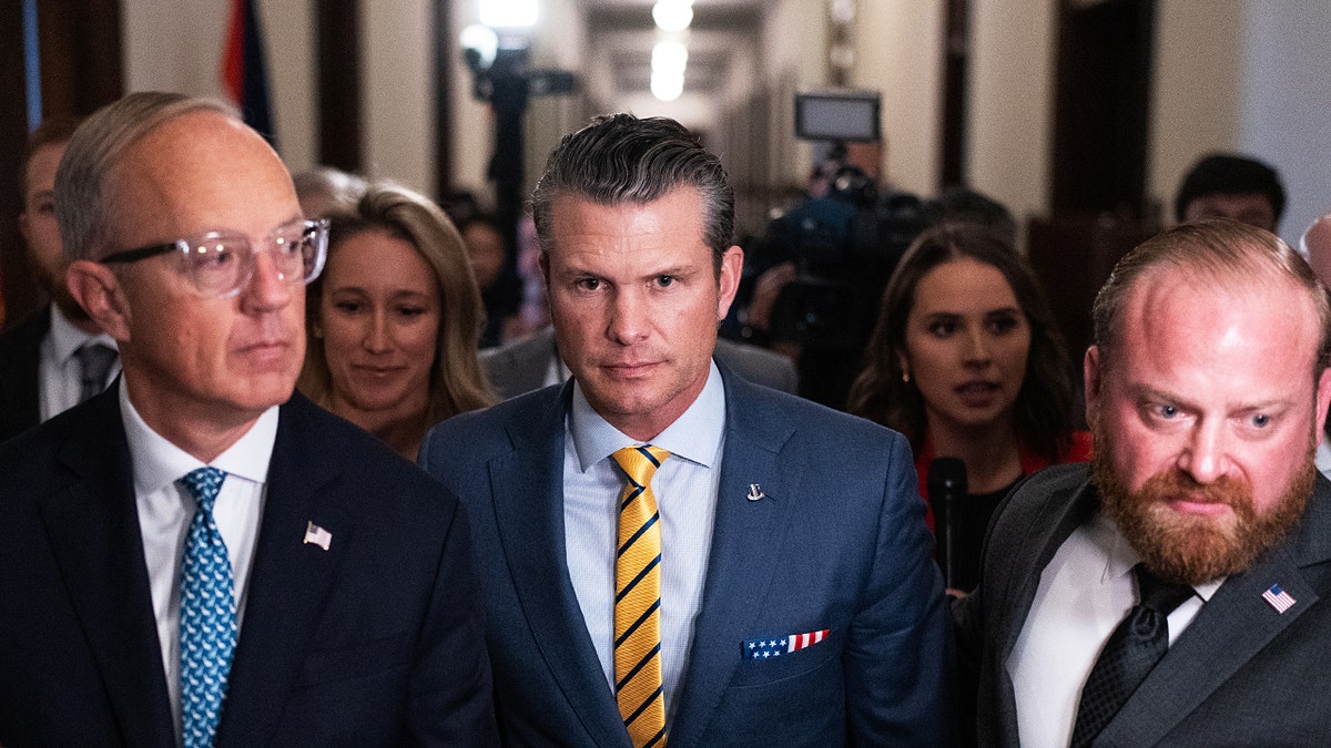 Pete Hegseth, center, walks to a meeting on Capitol Hill