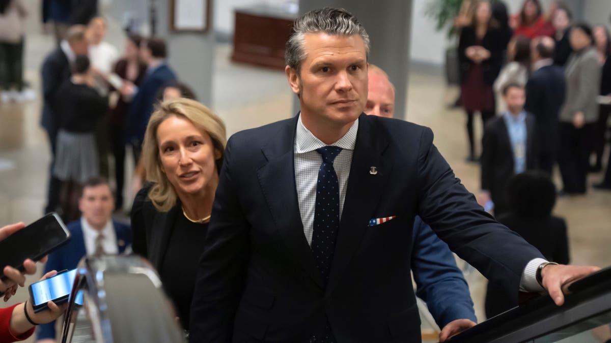 Pete Hegseth and wife on escalator