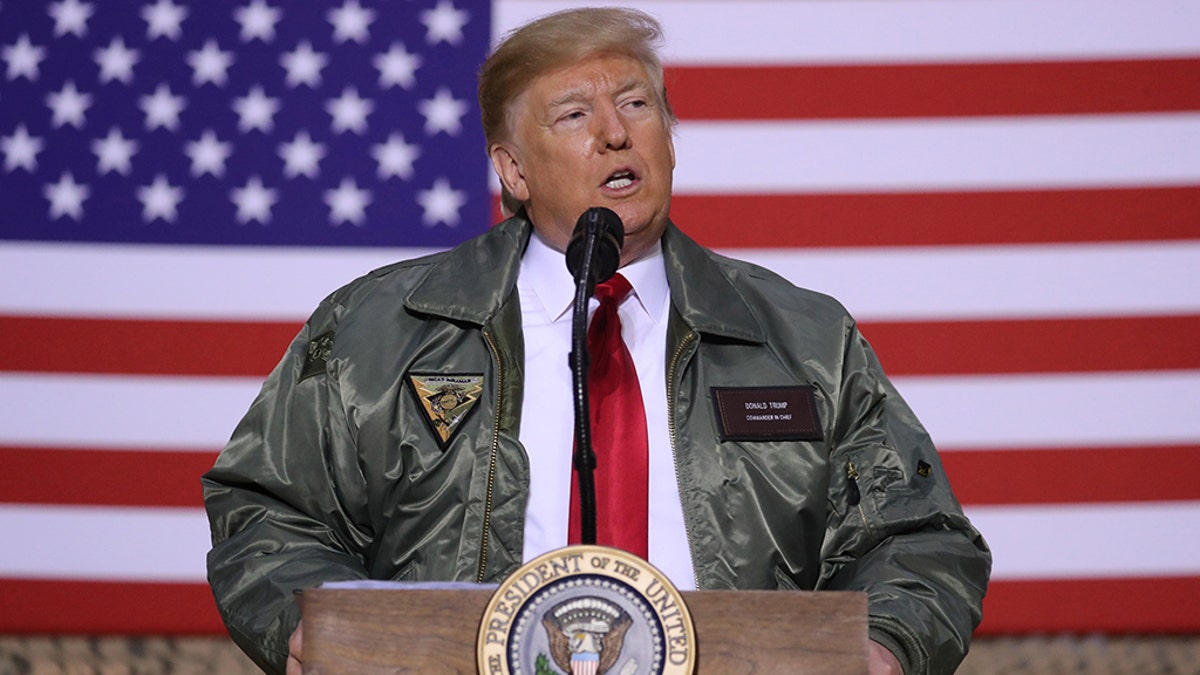 Trump in bomber jacket speaking at Iraq air base to troops in 2018