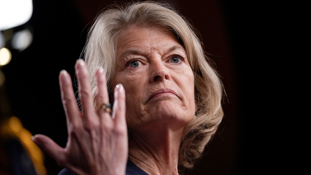 Sen. Lisa Murkowski with hand raised in closeup shot