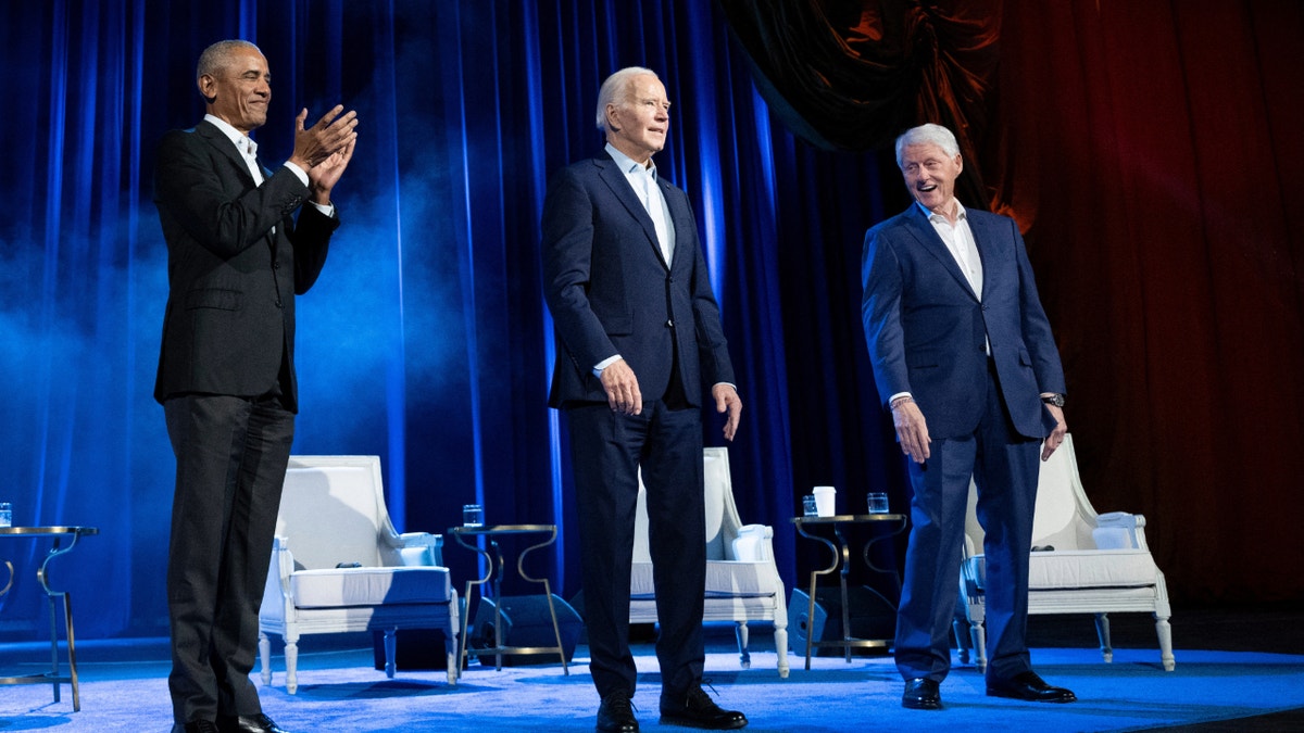 Biden, center, on stage with Obama, left, and Clinton, right