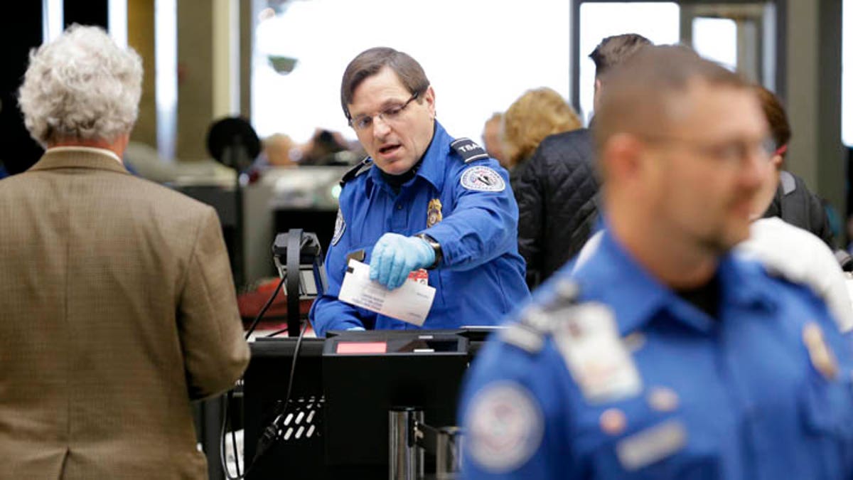 TSA agent checks a passenger ticket.