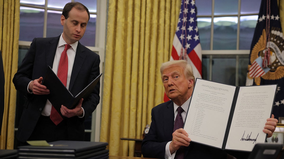 Donald Trump displaying pardon document