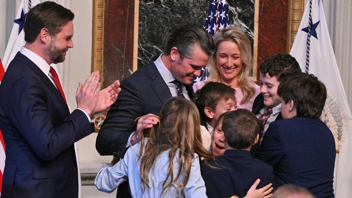 Secretary of Defense Pete Hegseth embraces his children after being sworn into office.