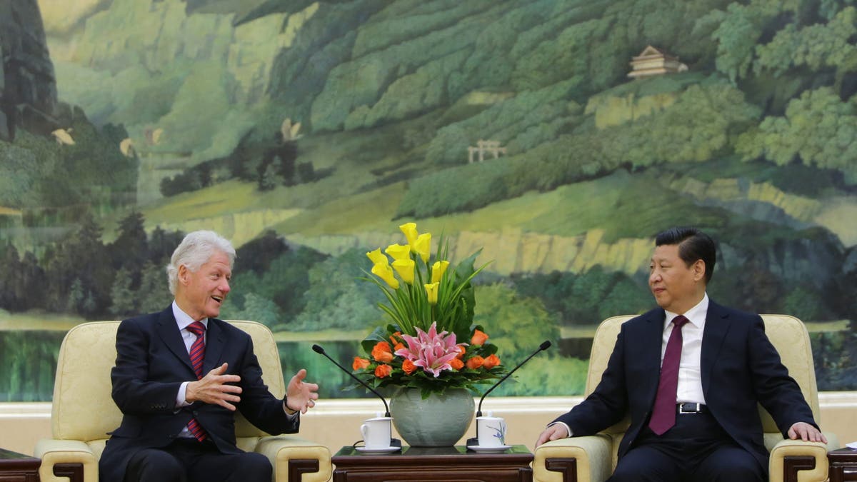 Former President Bill Clinton, left, speaks with Chinese President Xi Jinping in 2001.