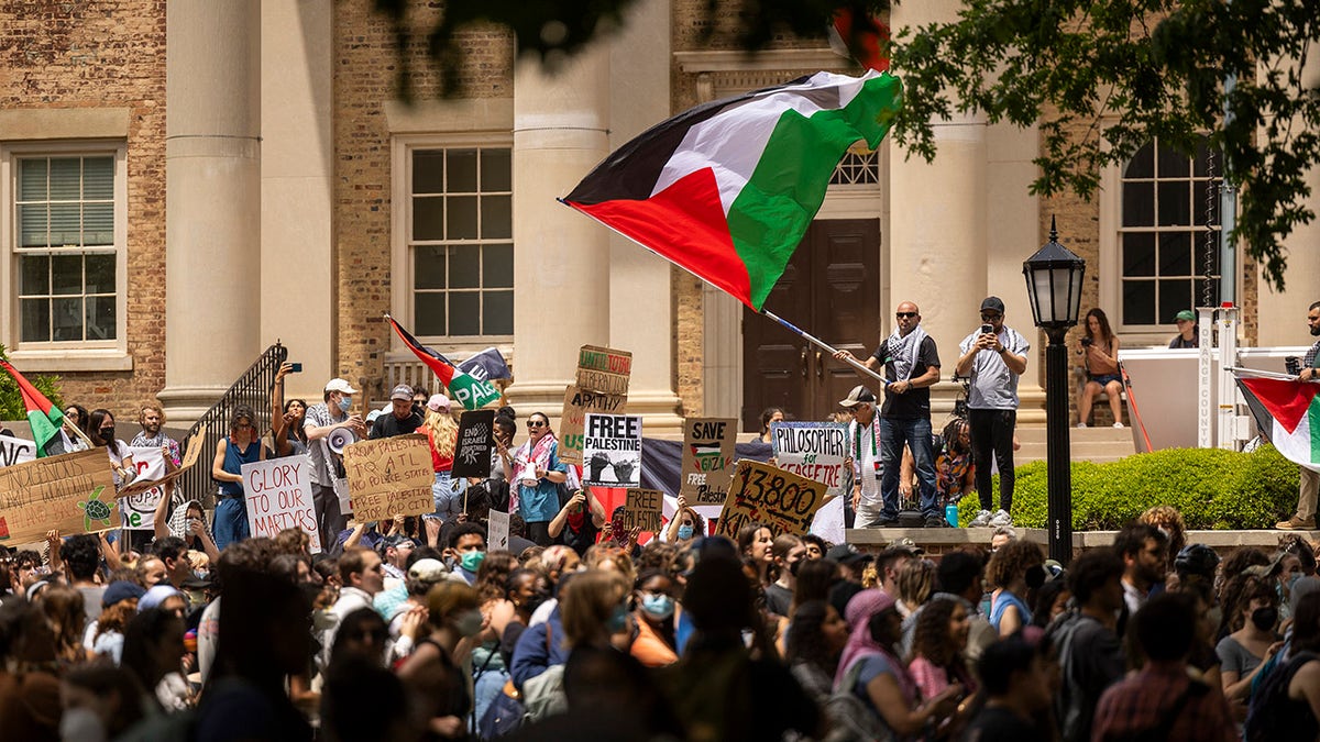 Anti-Israel protesters, one waving large Palestinian flag