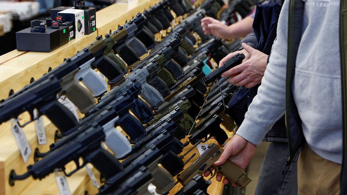 Customers examine handguns at a gun show in Iowa