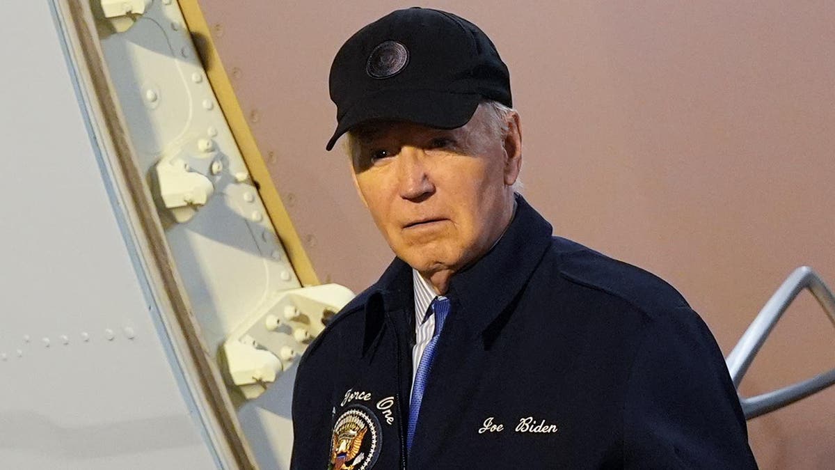 Joe Biden in jacket, ballcap 