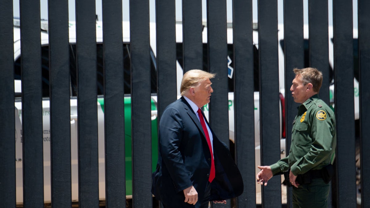 Trump with Border Patrol officer at border fence