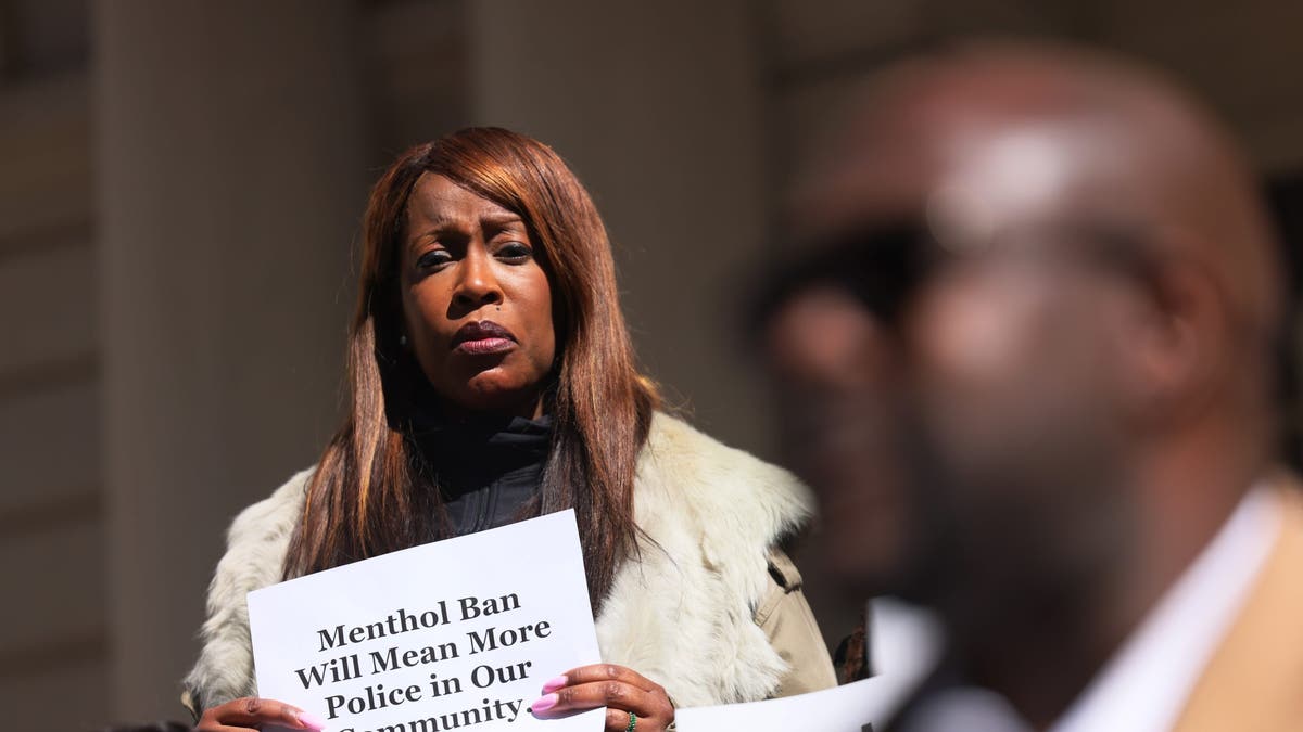 A woman in New York City holds up a sign on the steps of City Hall on March 9, 2023 in New York City. Members of Mothers of the Movement, a group of women whose African American children have been killed by police officers or by gun violence, held a rally against racism, inequality, and policies targeting people of color. 