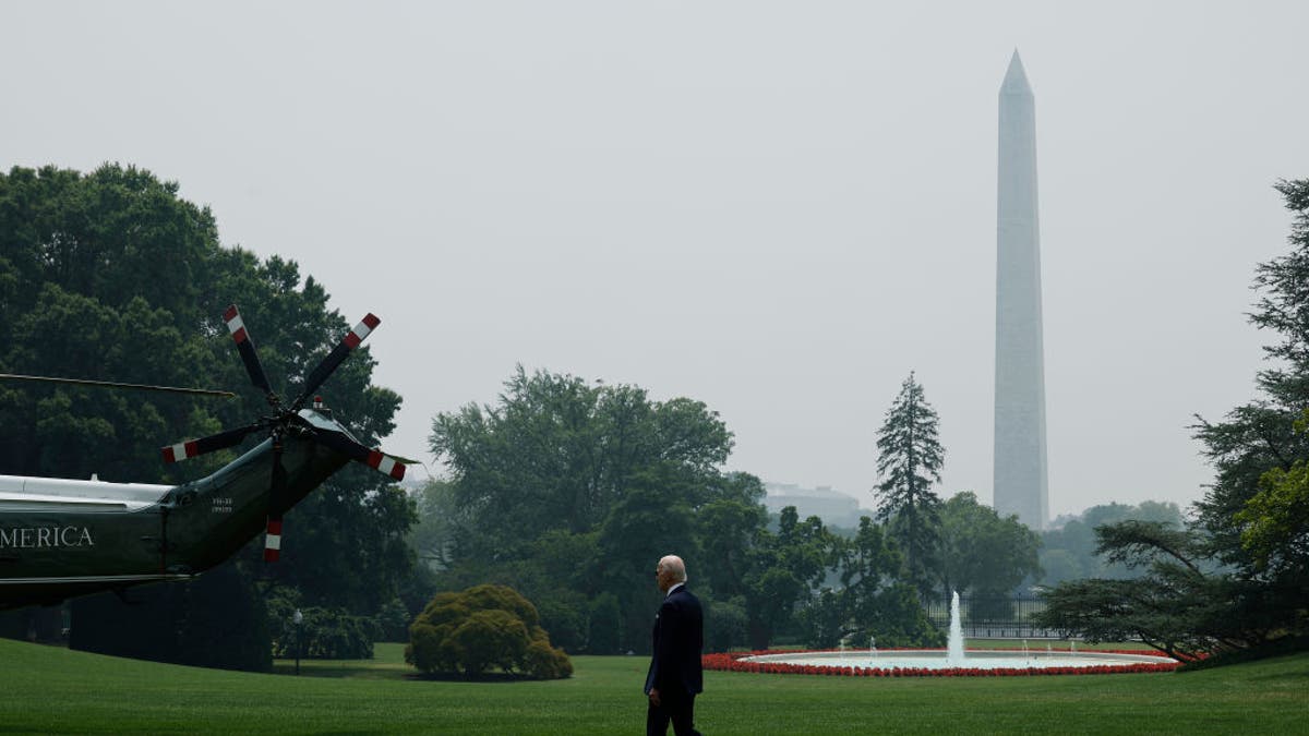 With wildfire smoke clouding the Washington Monument in the distance, President Biden walks across the South Lawn as he leaves the White House for a day trip to New York City on June 29, 2023 in Washington, D.C.