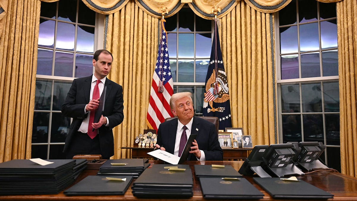 Trump with executive orders at the White House