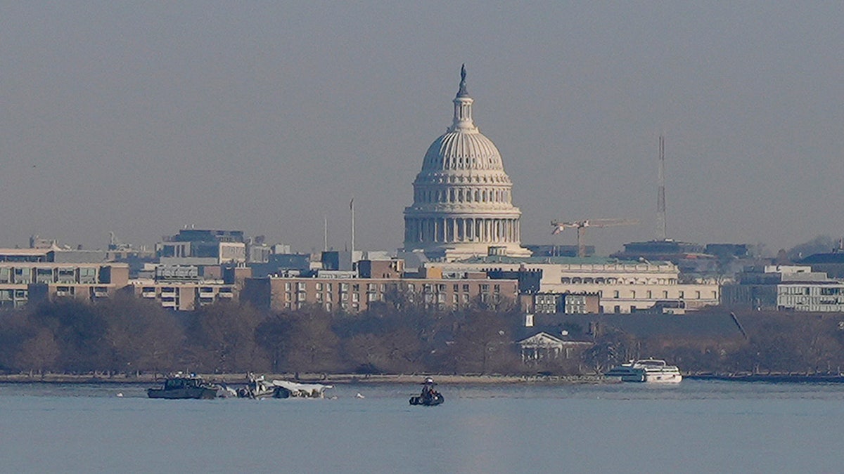 Search and rescue efforts are seen around a wreckage site in the Potomac River