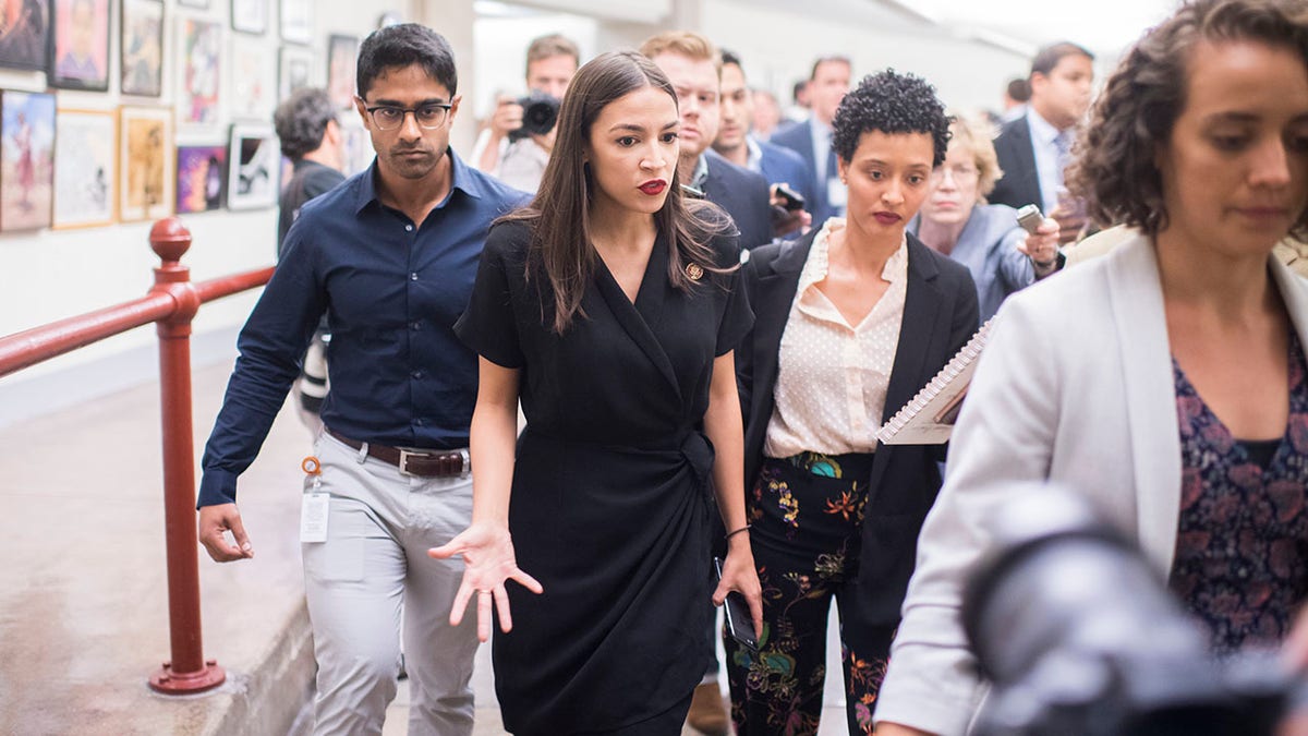 AOC, center, with Saikat Chakrabarti behind her on left