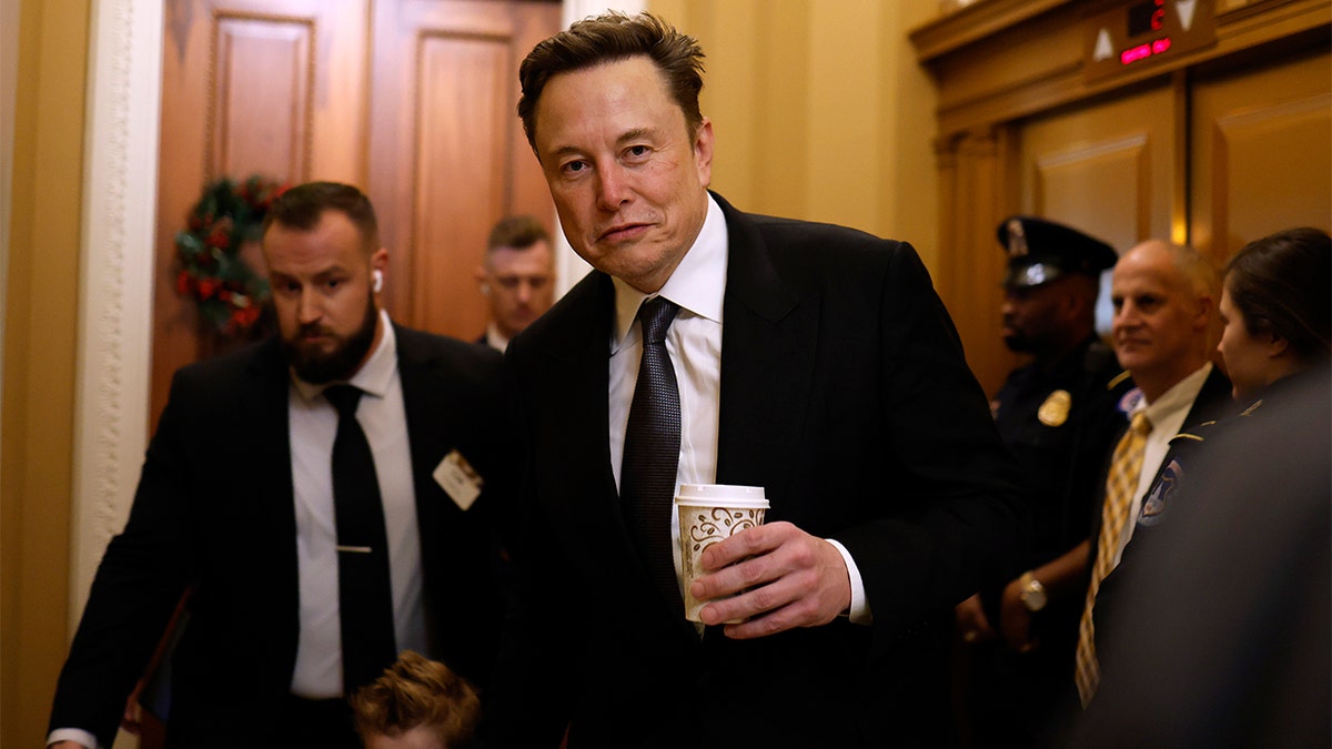 Elon Musk holds coffee cup at Congress